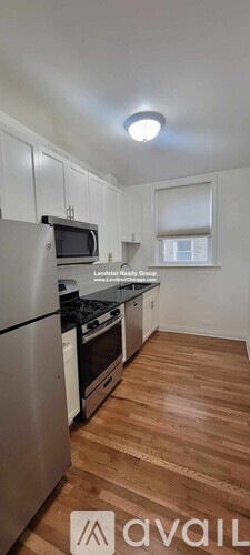 A kitchen with wooden floors and stainless steel appliances.