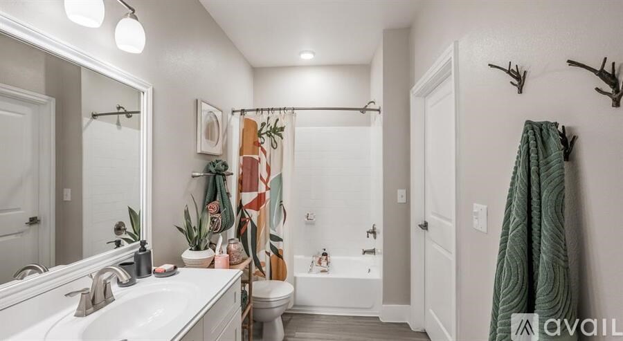 A bathroom with a white sink, a white bathtub, a white toilet, a white door, a white wall, a white ceiling, a white floor, a white mirror, a white shower curtain, a white