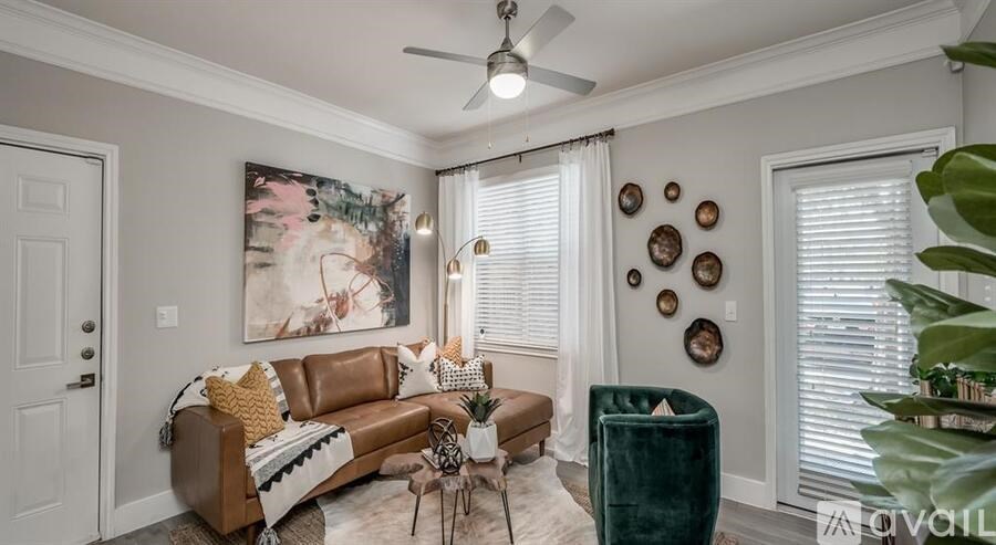A living room with a brown couch and a green armchair.