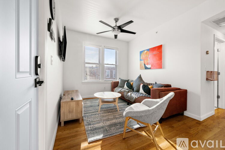 A living room with a red couch and a white chair.