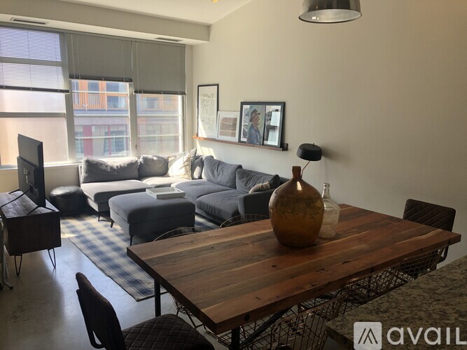 A living room with a wooden table and grey couches.