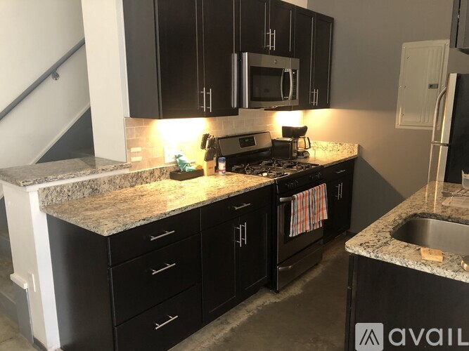 A kitchen with black cabinets and granite countertops.