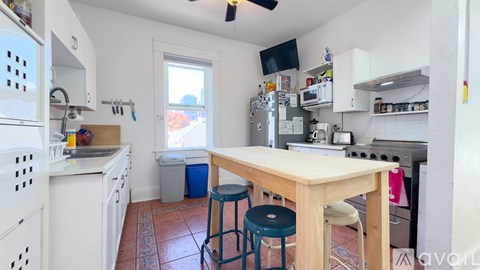 A kitchen with a table and two stools.