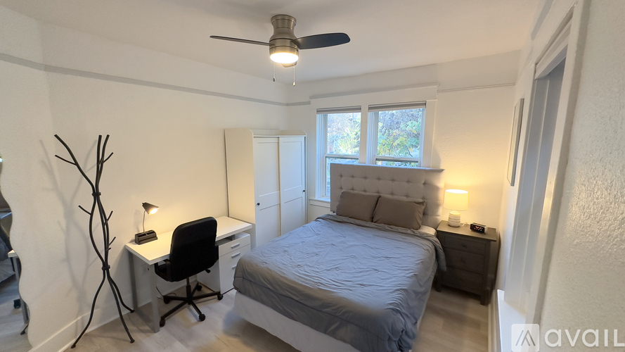 A bedroom with a bed, desk, and chair.