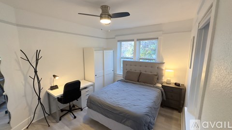 A bedroom with a bed, desk, and chair.