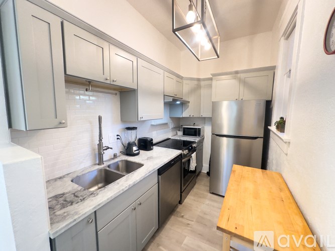 A kitchen with a sink, stove, and refrigerator.
