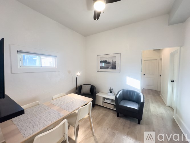 A room with a table, chairs, and a television.