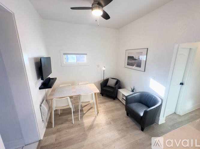 A room with a table, chairs, and a television.