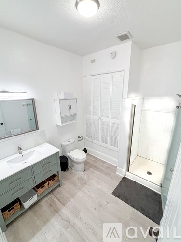 A bathroom with a sink, toilet, and shower.