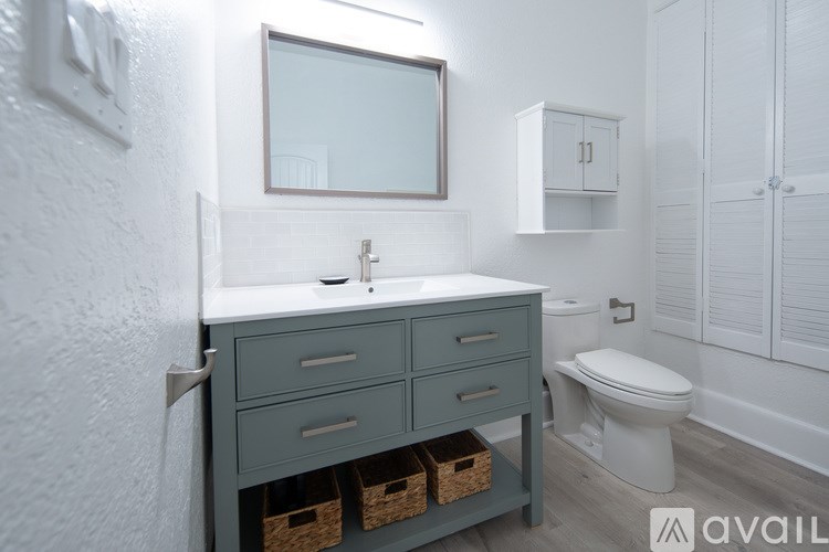 A bathroom with a white toilet and a sink with a mirror above it.