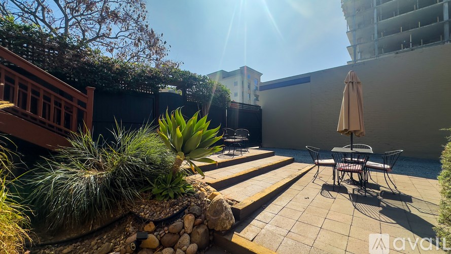 A sunny backyard with a patio table and chairs.