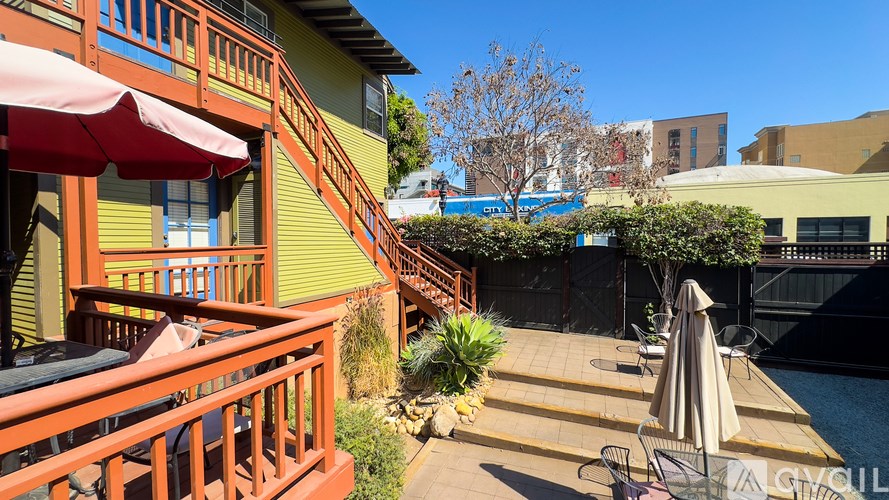 A patio with a table and chairs overlooking a pool.