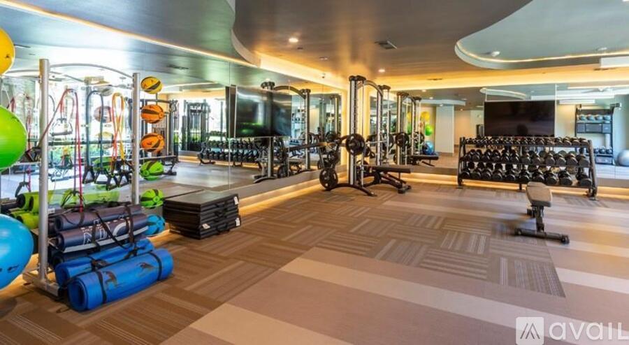 A gym with a variety of equipment including weights and exercise balls.