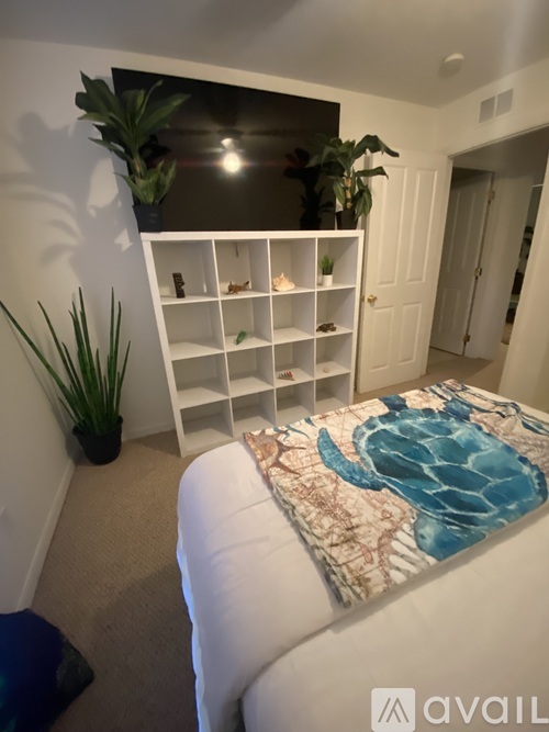 A bedroom with a bed and a shelf with plants on it.
