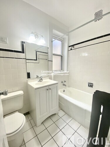 A white bathroom with a toilet, sink, and bathtub.