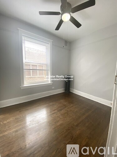 A room with a ceiling fan and wooden flooring.
