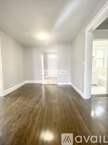 A room with wooden flooring and white walls.