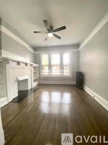 A room with a fireplace and a fan on the ceiling.