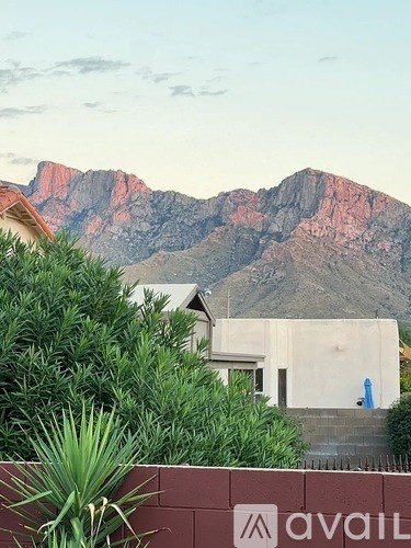 A mountain range with a house in the foreground and a sign that says "avail".