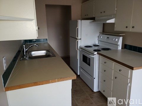 A kitchen with a white refrigerator, white oven, and a brown counter.