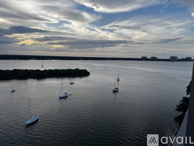 A serene harbor with boats and a cloudy sky at dusk.