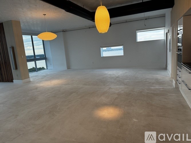 A spacious room with a large window and a view of the water.