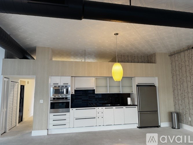 A modern kitchen with a black countertop and white cabinets.