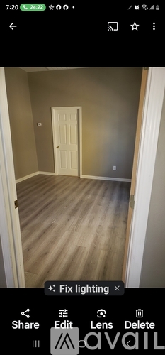 A room with a white door and wooden floor.