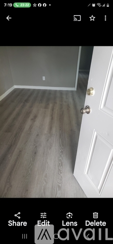 A white door with a handle and a small square on the wall.