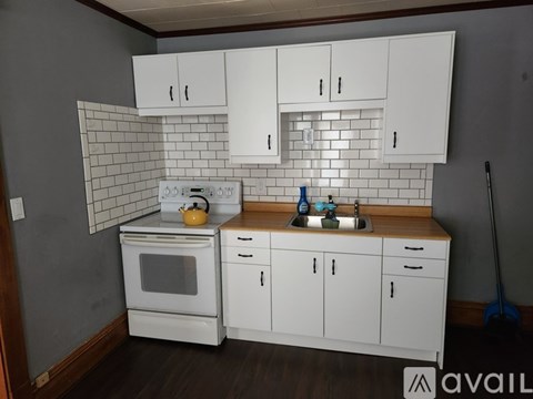 A kitchen with white appliances and cabinets.