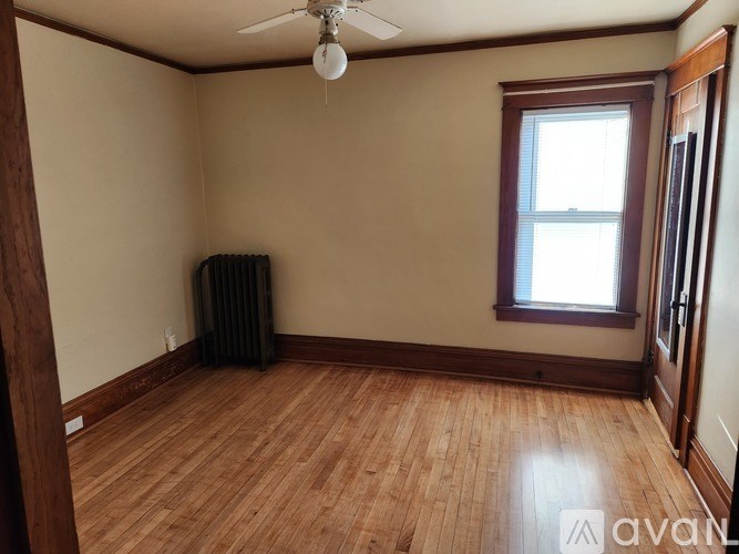 A room with wooden flooring and a ceiling fan.