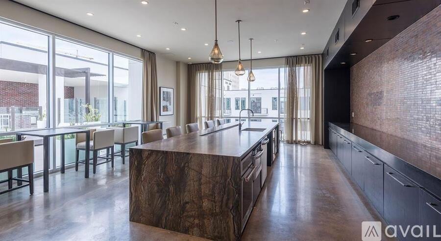 A modern kitchen with a large island and pendant lights.