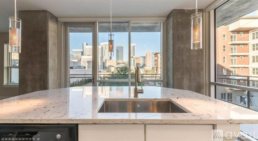 A modern kitchen with a marble countertop and a view of the city.