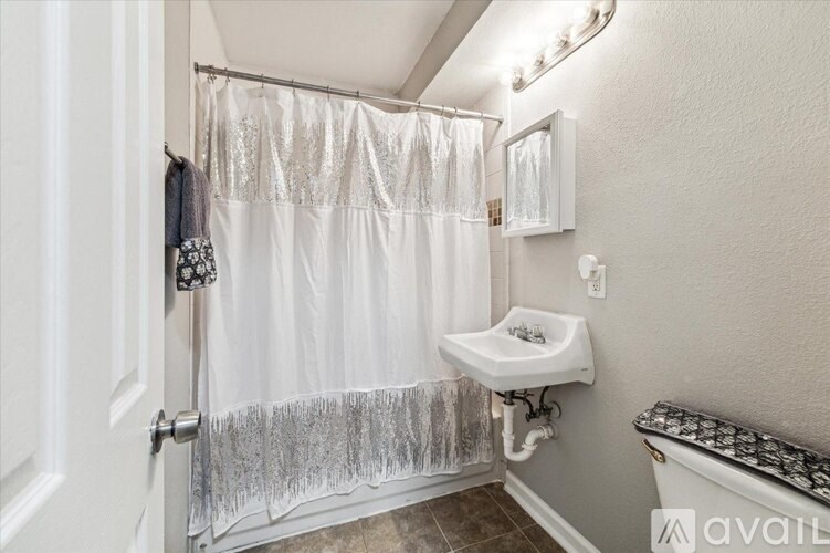 A bathroom with a white shower curtain and a white sink.