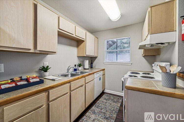 A kitchen with wooden cabinets and a window.