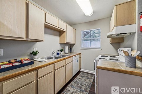 A kitchen with wooden cabinets and a window.
