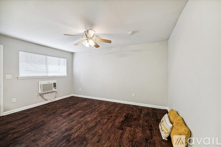 A room with a ceiling fan and a window with blinds.