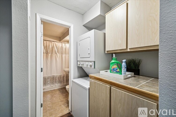 A small kitchen with a refrigerator, wooden cabinets, and a dishwasher.