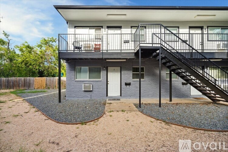 A modern house with a balcony and stairs leading to the entrance.