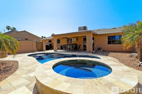 A house with a round pool in the middle of a patio.