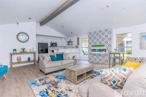 A living room with a grey couch and a patterned rug.