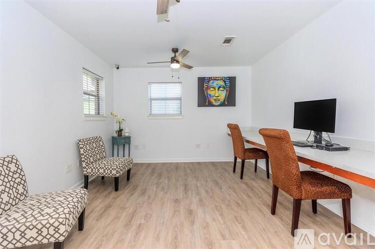 A living room with a sofa, chairs, and a television.