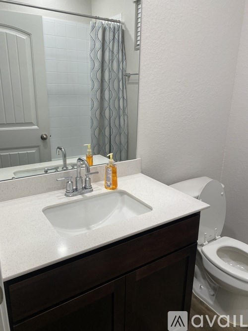 A bathroom with a white sink and a toilet.