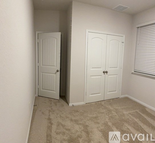 A room with two white doors and a carpeted floor.