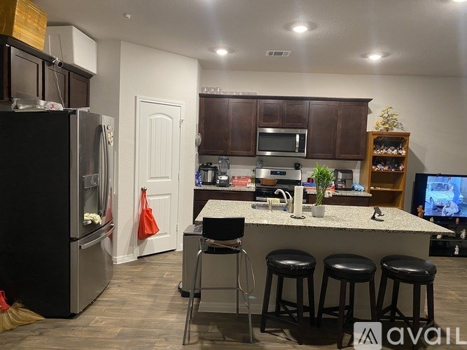 A kitchen with a black refrigerator and a white door.
