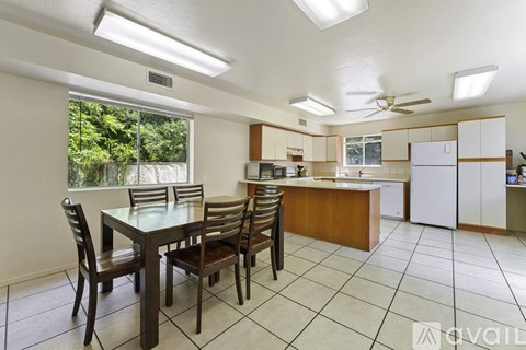A kitchen with a table and chairs in front of a window.