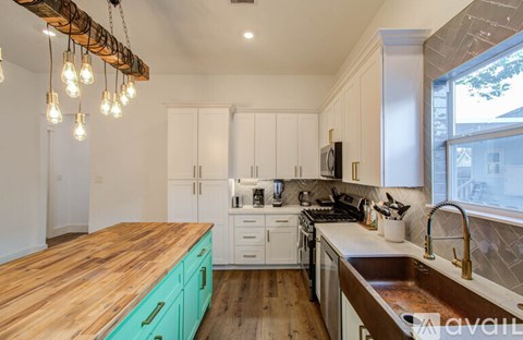 A kitchen with a wooden countertop and white cabinets.
