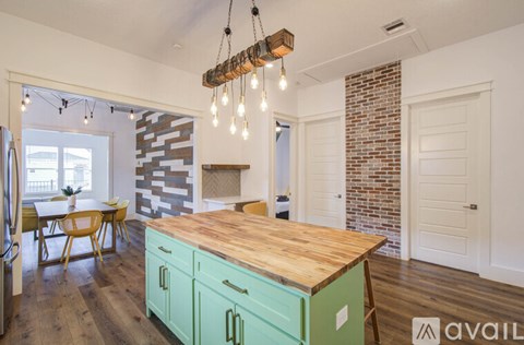 A kitchen with a wooden countertop and green cabinets.