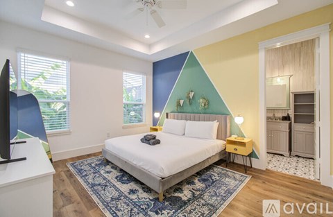 A bedroom with a bed, a ceiling fan, and a rug.