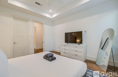 A bedroom with a bed, dresser, and mirror.